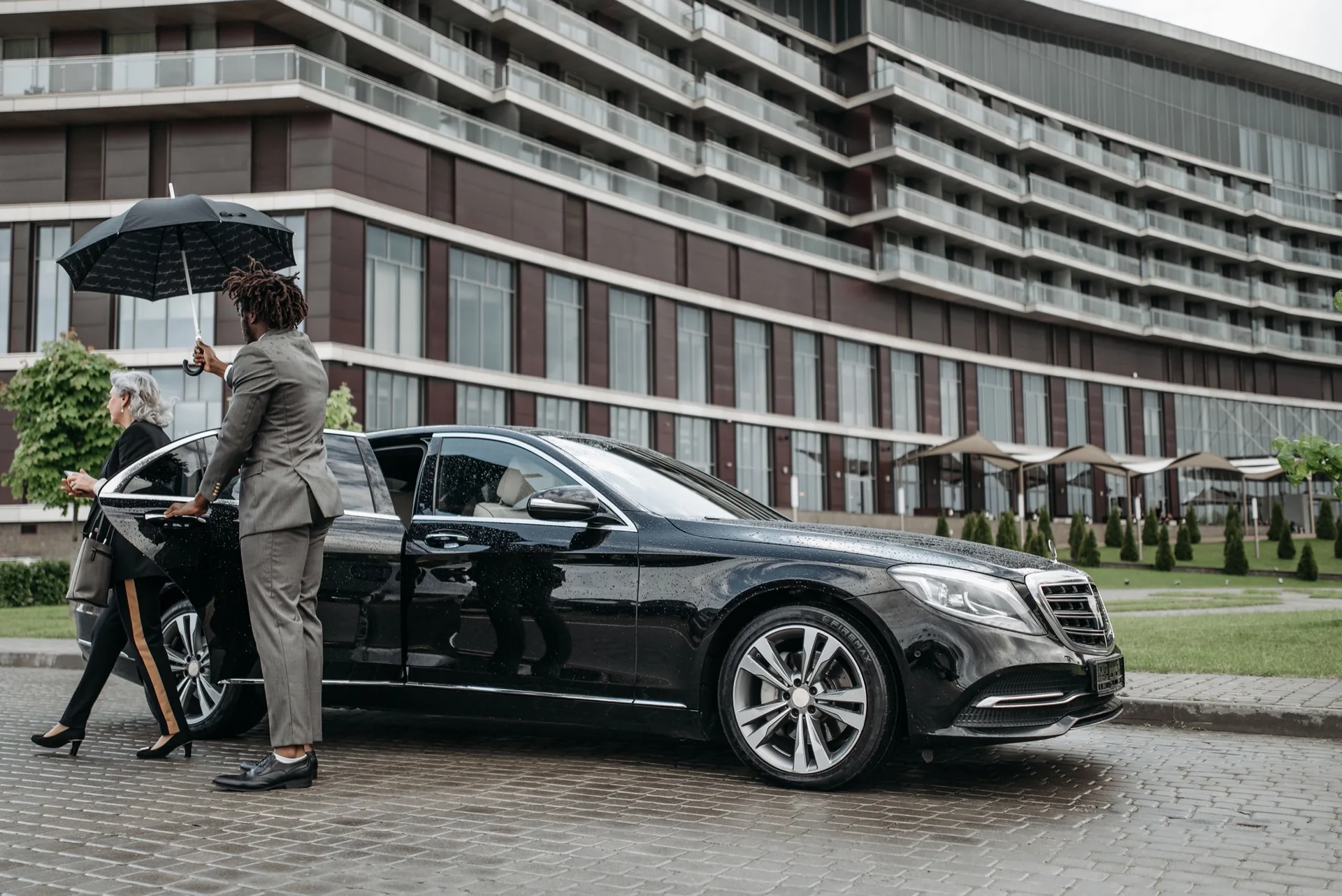 Afsahi chauffeur opening a luxury car door for a client