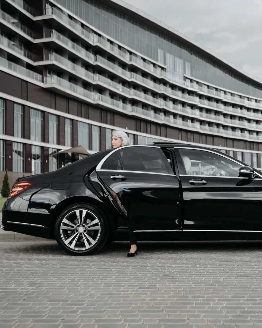 Executive stepping out of a black Mercedes-Benz S-Class held by an Afsahi chauffeur outside a corporate hotel in Morocco